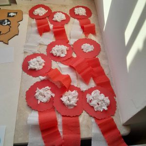 Zdjęcie ułożonych na parapecie biało czerwonych kotylionów.