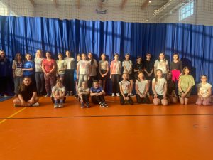 Uczennice uczestniczące w zajęciach z zumby pozują do wspólnego zdjęcia z Panią trenerką.