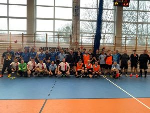 Zawodnicy biorący udział w meczu pozują do wspólnego zdjęcia.