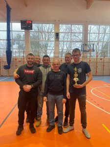 Sześcioro mężczyzn biorących udział w turnieju pozuje do wspólnego zdjęcia. Jeden z nich trzyma puchar.