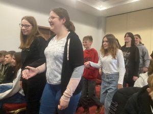 Uczniowie klasy ósmej tańczą w parach ustawieni para za parą.