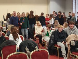 Uczniowie ustawieni w pary przygotowują się do zatańczenia belgijki. W pierwszej parze stoi Pan Robert Baca wraz z jednym z uczniów.