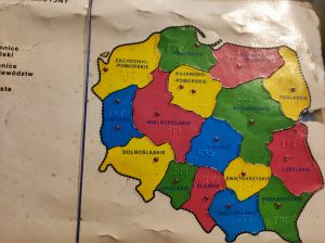 Zdjęcie mapy Polski z zaznaczonymi na kolorowo województwami i podpisanymi nazwami w języku braille'a.