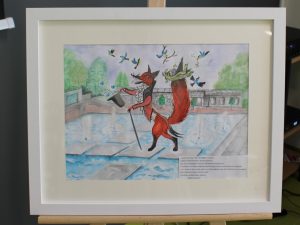 Zdjęcie oprawionej w białą ramę pracy uczennicy Felicji Bizoń, która otrzymała w konkursie specjalną nagrodę dyrektora. Rysunek przedstawia kota chodzącego po płytkach ułożonych w fontannie.