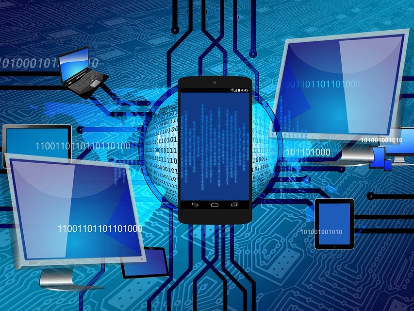 Na niebieskim tle z zarysem jasnych elementów układu scalonego, grafiki ekranów oraz ciągi liczbowe złożone z 0 i 1.