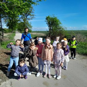 Uczniowie oddziału przedszkolnego pozują do wspólnego zdjęcia stojąc na drodze gruntowej.