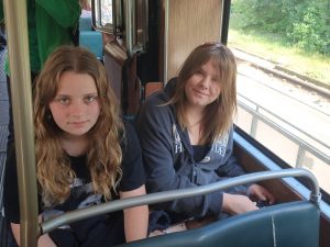 Dwie uczennice pozują do wspólnego zdjęcia siedząc w tramwaju.