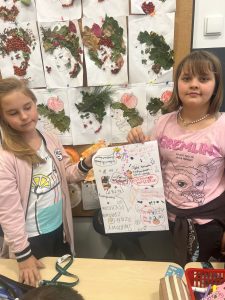 Dwie uczennice pozują do wspólnego zdjęcia trzymając w dłoniach między sobą wykonany plakat z okazji Światowego Dnia Zdrowia Psychicznego.