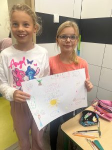 Dwie uczennice przebywające na świetlicy pozują do wspólnego zdjęcia trzymając wspólnie przed sobą wykonany plakat z okazji Światowego Dnia Zdrowia Psychicznego.