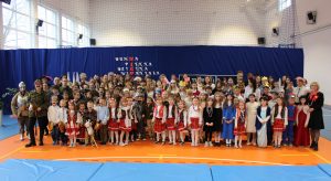 Wszyscy uczniowie szkoły wraz z nauczycielami pozują do wspólnego zdjęcia na sali gimnastycznej. Dzieci wraz z nauczycielami są przebrane w stroje historyczne .