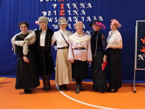 Sześć nauczycielek pozuje do wspólnego zdjęcia stojąc obok siebie. Panie ubrane są w stroje eleganckich dam z lat dwudziestych.