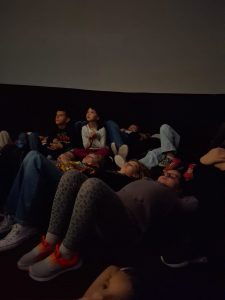 Uczniowie leżą wygodnie w kopule patrząc nad siebie. Dzieci widoczne na pierwszym planie mają podciągnięte kolana w górę i oparte stopy o podłoże.