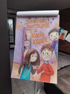 Zdjęcie plakatu narysowanego odręcznie, na którym widać postacie dzieci oraz napis "SPOTKANIE AUTORSKIE Z KASIĄ KELLER".