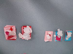 Zdjęcie pięciu równo ułożonych kupek utworzonych z karteczek walentynkowych.