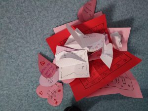 Zdjęcie luźno leżących obok siebie karteczek walentynkowych, na których można odczytać że są napisane dla pracowników szkoły