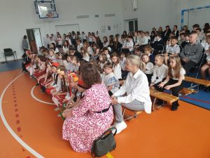 Zdjęcie siedzących na widowni podczas apelu uczniów i ich opiekunów.