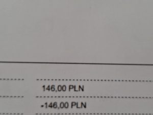 Na białej kartce widoczne są oddzielone przerywanymi liniami wartości liczbowe: 146,00 PLN oraz -146,00 PLN.