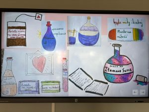 Na ekranie multimedialnym wyświetlone są dziecięce rysunki przedstawiające „lekarstwa na złamane serce”. Widać m.in. butelki z napisami „Eliksir na złamane serce”, „Eliksir na szczęście”, pudełko „Herbata miłości”, „Plaster na miłość”, kremy i mikstury. Obok narysowane są kartki z receptami i rysunki serc.