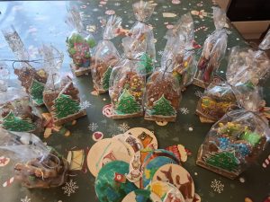 Gotowe, zapakowane pierniki świąteczne ustawione na stole, przygotowane jako upominki.