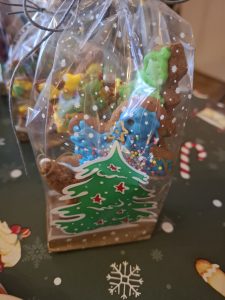 Zbliżenie na zapakowany piernik w kształcie postaci, ozdobiony kolorowym lukrem i posypkami.