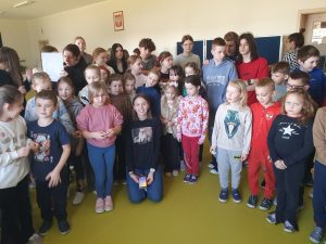 Uczniowie klas 0–3 oraz uczniowie klas 7 i 8 zgromadzeni podczas Dnia Nauk Przyrodniczych po zakończeniu prezentacji eksperymentów.