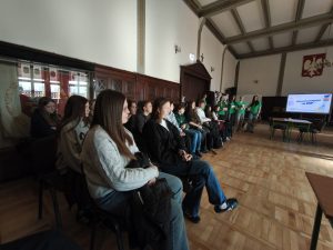 Ósmoklasiści słuchają prezentacji przygotowanej przez uczniów i nauczycieli ZSP w Chełmży.