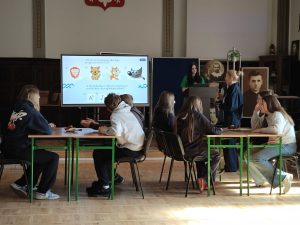 Ósmoklasiści biorą udział w quizie w grupach podczas wizyty w ZSP w Chełmży.