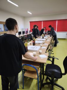 Uczniowie przygotowują w klasie poczęstunek z pizzą i napojami na wspólne świętowanie.