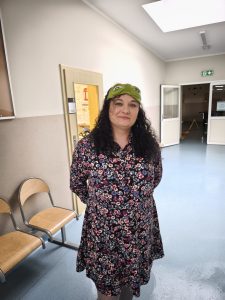 Pani z obsługi szkoły w stroju piżamowym stoi na szkolnym korytarzu podczas obchodów Pierwszego Dnia Wiosny – Dnia w Piżamie.