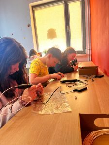 Uczniowie tworzą modele przy użyciu długopisów 3D podczas warsztatów.