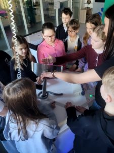 Uczniowie uczestniczą w doświadczeniu przy stanowisku demonstracyjnym, obserwując działanie radaru.