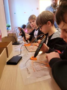 Uczniowie korzystają z długopisów 3D, tworząc modele z tworzywa sztucznego.