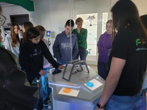 Uczniowie obserwują doświadczenie z kulkami Newtona na stanowisku demonstracyjnym w Laboratorium Wyobraźni.