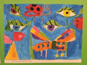 Kolorowa praca plastyczna z abstrakcyjnymi kształtami i motywami przypominającymi oczy i rośliny.