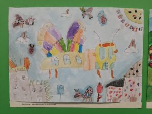 Praca plastyczna przedstawiająca fantastyczne budynki i owady w kolorowej scenerii.