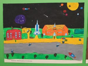 Praca plastyczna przedstawiająca futurystyczne miasto z planetami i pojazdami kosmicznymi.