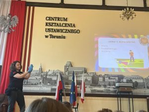 Szkolenie z pierwszej pomocy w Centrum Kształcenia Ustawicznego w Toruniu – prowadząca omawia zasady bezpieczeństwa.