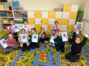 Uczniowie klas I–III prezentują materiały edukacyjne i pomoce do nauki pierwszej pomocy otrzymane w programie.