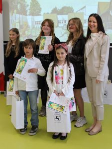 Grupa nagrodzonych uczniów oraz przedstawicielka organizatorów podczas pamiątkowego zdjęcia po wręczeniu dyplomów i nagród.