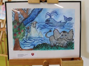 Praca plastyczna przedstawiająca fantastyczne zwierzęta, między innymi słonia, wieloryba i białego koguta. Zwierzęta umieszczono w baśniowym krajobrazie z wodą, drzewami i kolorowymi roślinami. Dominują odcienie błękitu i zieleni.