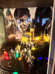 Makieta zamku Hogwart wykonana z klocków LEGO prezentowana w Muzeum Klocków LEGO i Gier Komputerowych. W tle widoczna grafika nawiązująca do serii Harry Potter.