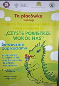 Plakat programu edukacyjnego „Czyste Powietrze Wokół Nas”, skierowanego do dzieci w wieku przedszkolnym i ich rodziców. Na plakacie znajduje się zielony smok – symbol programu.