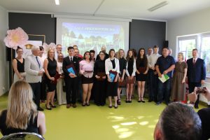 Absolwenci klasy 8a ze szkoły w Łysomicach wraz z rodzicami, wychowawcami i przedstawicielami władz pozują do pamiątkowego zdjęcia po zakończeniu wręczenia nagród.