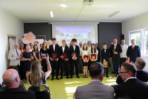 Absolwenci szkoły podstawowej w Turznie wraz z rodzicami i przedstawicielami samorządu pozują do wspólnego zdjęcia podczas Gali Absolwentów Gminy Łysomice.