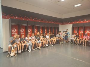 Uczniowie siedzą w szatni reprezentacji Polski na Stadionie Narodowym podczas zwiedzania zaplecza stadionu.