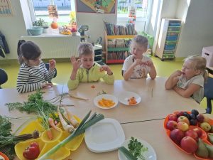 Dzieci z oddziału przedszkolnego degustujące warzywa podczas zajęć o zdrowych nawykach żywieniowych.