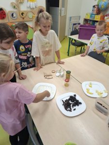 Dzieci poznają różne smaki, próbując przygotowanych produktów spożywczych.