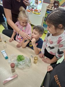 Dziecko rozpoznaje zapach produktu podczas zajęć poświęconych poznawaniu świata za pomocą zmysłów.
