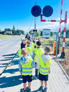 Dzieci z oddziału przedszkolnego poznają zasady bezpiecznego zachowania w pobliżu przejazdu kolejowego.