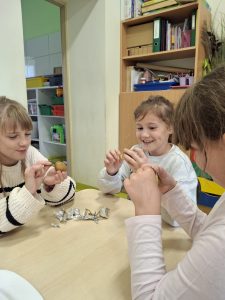 Uczennice rozpakowują upieczone ziemniaki z folii podczas wspólnego poczęstunku w świetlicy.